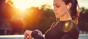 Woman checking her fitness tracker data after a workout, looking for reassurance in the numbers